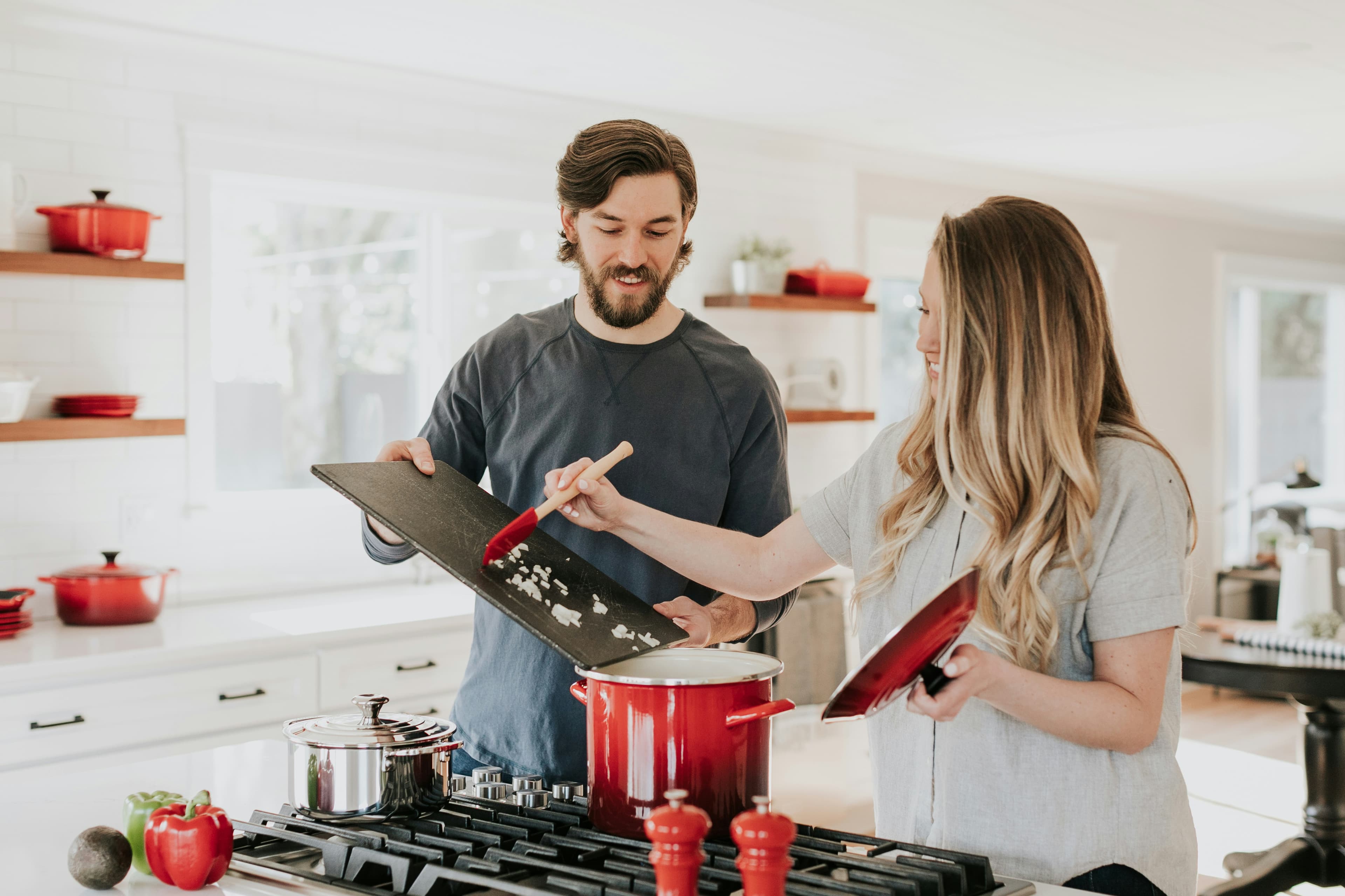 Cucina contemporanea bianca con superfici luminose e dettagli in legno